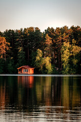 wooden house on the edge of the lake and forest