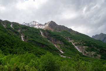 Three waterfalls flow down from the mountain