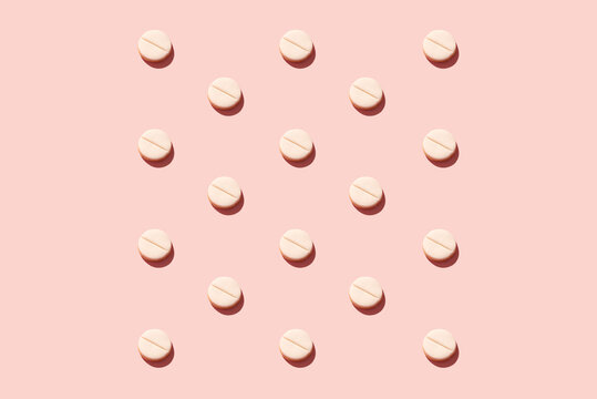 Pills on pink background.