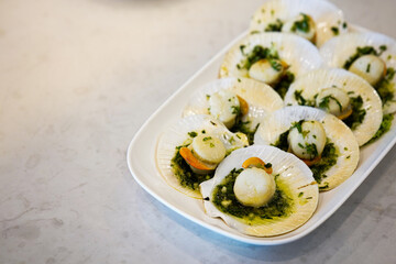 selective focus, Seared scallops shell with butter, garlic and parsley on white plate.