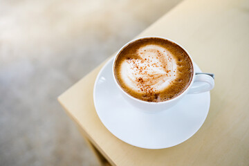 selective focus, a cup of hot latte coffee with beautiful milk foam latte art texture on wood table. Overhead view, copy space. Advertising for cafe menu. Coffee shop menu.