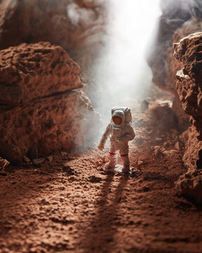 Astronaut on cocoa rocky surface.
