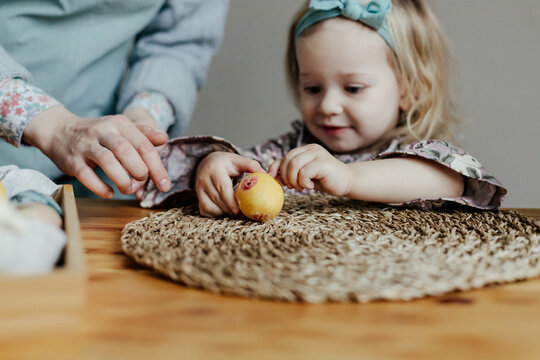 Child decorating egg with sticker on Easter