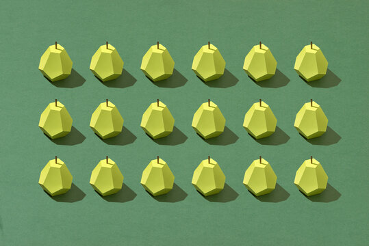 Pear fruit made of paper. Green background.
