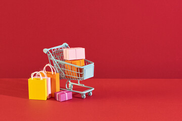 colorful box gift in mini cart and shopping paper bag for commercial