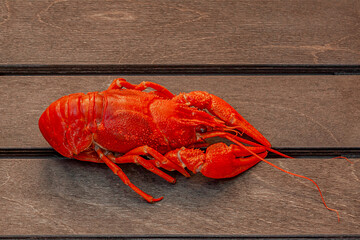 Red boiled crawfish on a wooden brown board. Close-up.