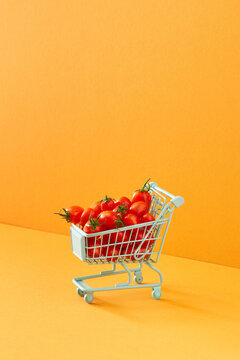 Small cart with tomatoes on a light orange background