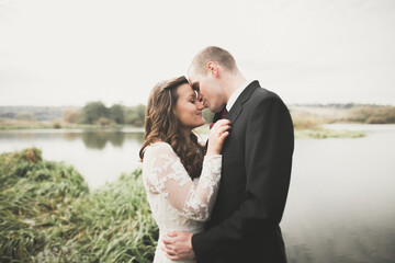 Perfect couple bride, groom posing and kissing in their wedding day