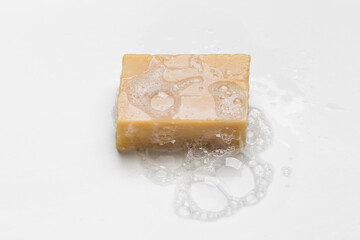 Soap bar and foam on white background