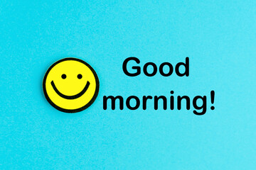 Good morning! Yellow emoticon on bright blue background. Good day wishes. Smile and positive