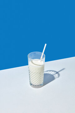 Glass of fresh natural milk with paper straw.