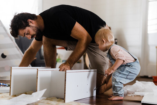 Father and daughter constructing shelves