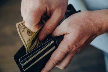 hands of a working man counting dollar bills in an empty wallet. Poverty concept. dismissal or...