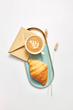 Handmade envelope, cappucino and croissant.