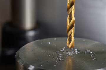 metal drill bit make holes in steel billet on industrial drilling machine. Metal work industry....