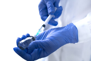 Hand holding syringe and vaccine.