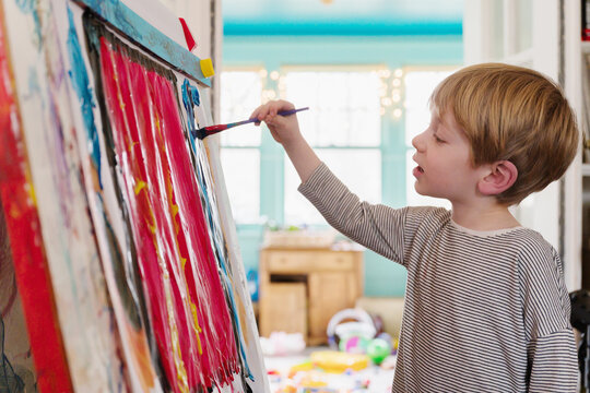 Preschool-Aged Boy Painting on Easel at Home