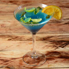 Blue curacao cocktail decorated with lemon slice and mint leaves. Selective focus on top