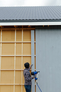 Man installing siding on house wall