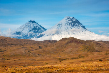 Snowy volcanoes mountains on a blue sky background on Kamchatka.