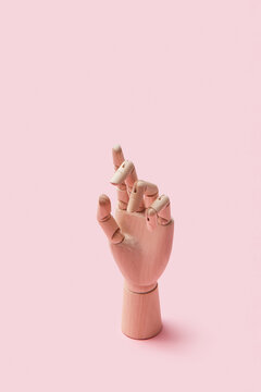 Wooden hand shows gesture.