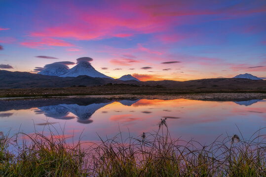 Sunset with volcanoes mountains with clouds on Kamchatka Peninsula.