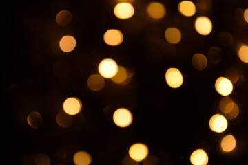 Lights blurred golden bokeh abstract on dark background, rozmyte światełka na ciemnym tle lampki świąteczne - obrazy, fototapety, plakaty