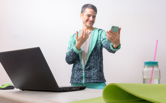 Happy Man Dancing Zumba Online Audience. Front Dance Teacher Greeting His Students. Young Man Dancing In The Living Room At Home. Fitness Exercises At Home.