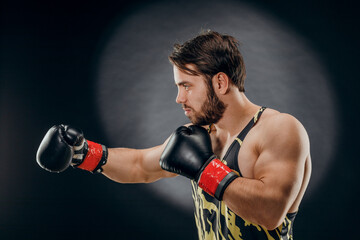 Plakat A man in Boxing gloves. A man Boxing on a black background. The concept of a healthy lifestyle