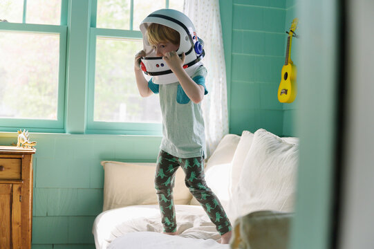 Boy Imagining on Couch with Astronaut Helmet