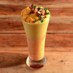 Mango Mastani, indian street food mango juice and ice cream blended and topped with dry fruits and...