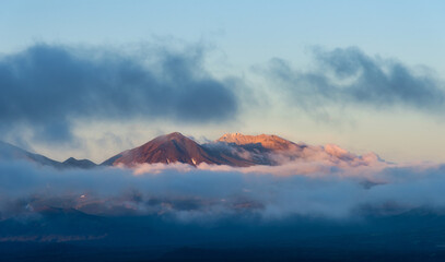 Cloudy frame with tops of Mutnovsky volcano, Kamchatka Peninsula.