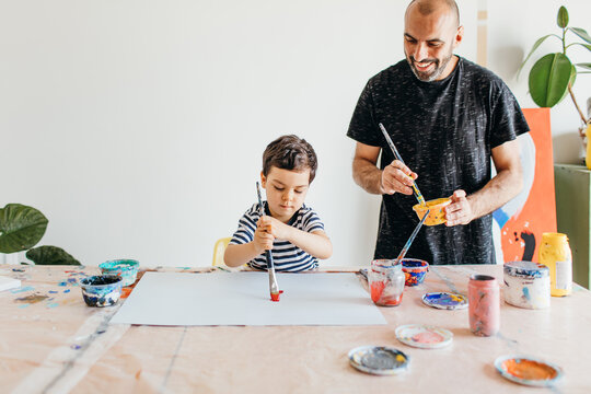A kid and this father painting at home