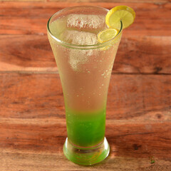 Lemon Mojito served in a glass over a rustic wooden background,a refreshing drink for summer days, selective focus on top