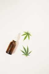 Brown bottles with cbd oil flat lay on white background. Cannabis leaf. Marijuana cosmetics. Vertical orientation 