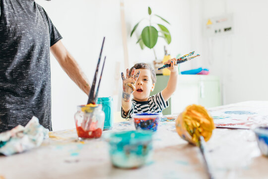 A kid and this father painting at home