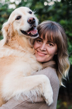 woman and golden retriever pose for a photo