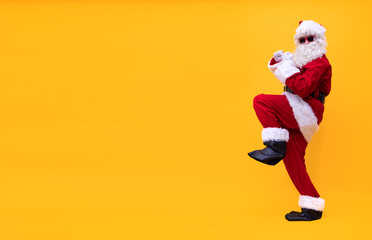 Weihnachtsmann tanzt fröhlich vor gelben Hintergrund