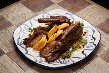 Roasted duck with quince on wooden table background