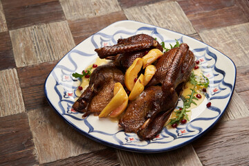 Roasted duck with quince on wooden table background