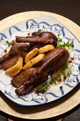 Roasted duck with quince on wooden table background