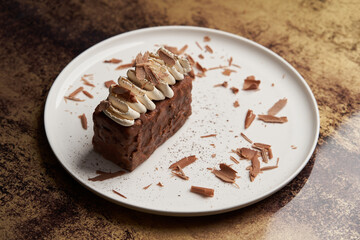 Piece of chocolate cake with whipped cream on white plate