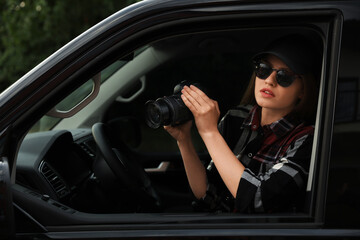 Obraz na płótnie Canvas Private detective with camera spying from car
