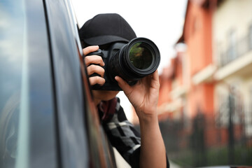 Private detective with camera spying from car