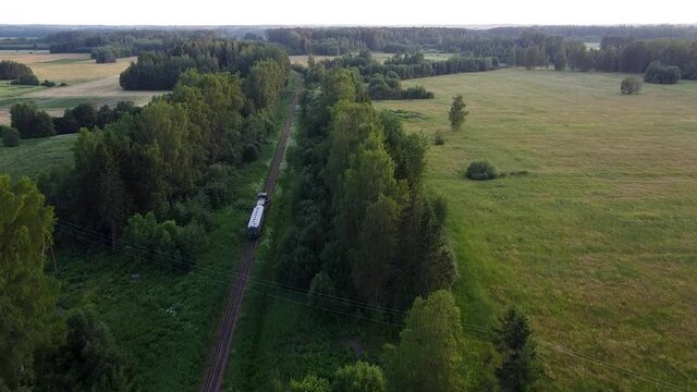 Narrow-gauge railroad train moving through country side landscape aerial view