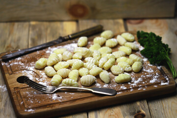 Raw gnocchi on a wooden board. Cooking gnocchi. Italian Cuisine.