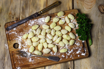 Raw gnocchi on a wooden board. Cooking gnocchi. Italian Cuisine.