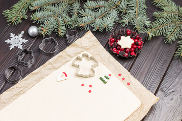 Preparing Christmas treat. Dough for baking cookies on paper. Cookie cutter molds. Metal form with...