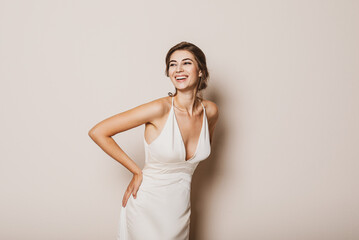Young bride wearing beautiful wedding dress on beige background. Space for text