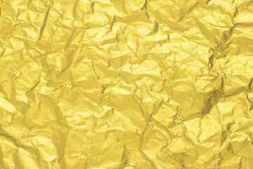 Illuminating golden paper texture. Wrinkled foil background. Color of the year 2021.